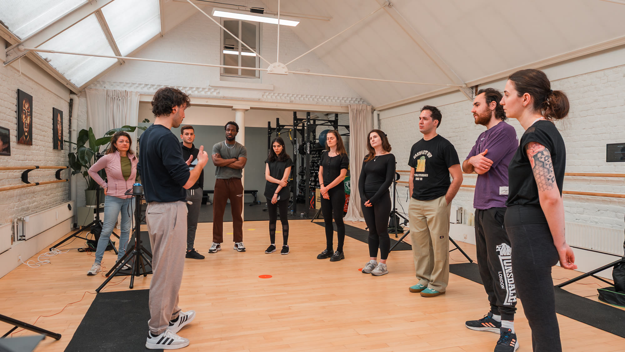 A coach briefing a circle of participants at the start of a Cogniflux Lab Open Lab session at Lokahi Studio in Brussels.